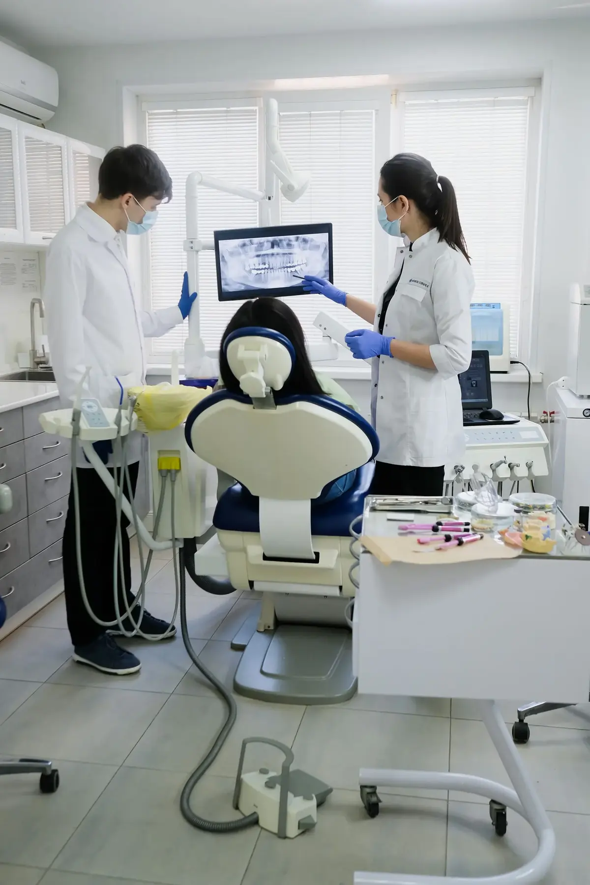 Equipe odontológica analisando a tomografia para planejar a instalação do implante dentário
